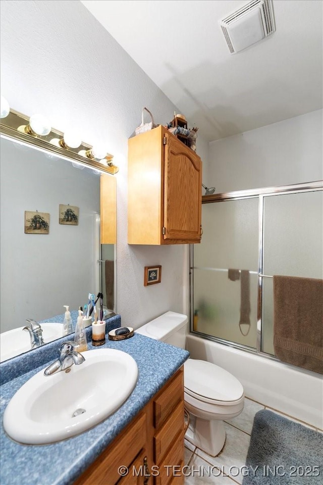 full bathroom featuring enclosed tub / shower combo, tile patterned floors, toilet, and vanity