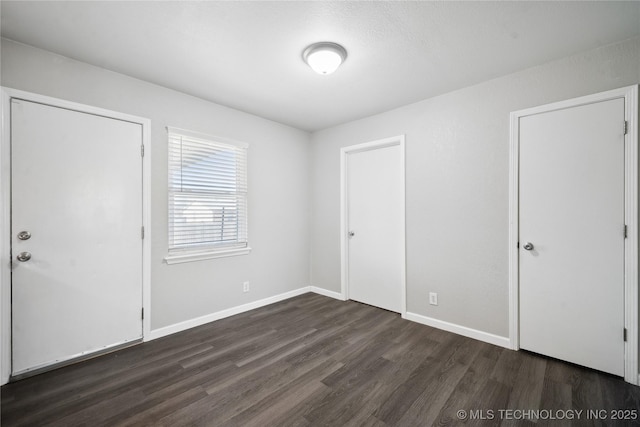 unfurnished bedroom featuring dark hardwood / wood-style flooring