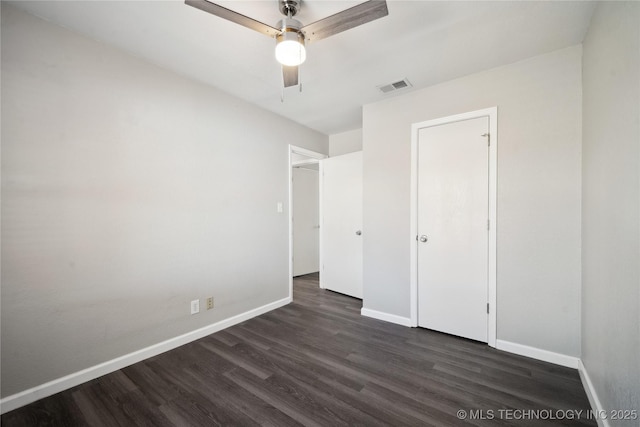 unfurnished bedroom featuring ceiling fan, dark wood-type flooring, and a closet