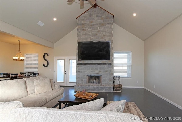 living room featuring vaulted ceiling with beams, ceiling fan with notable chandelier, a large fireplace, and french doors