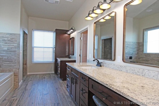 bathroom with wood-type flooring, vanity, and a bathing tub