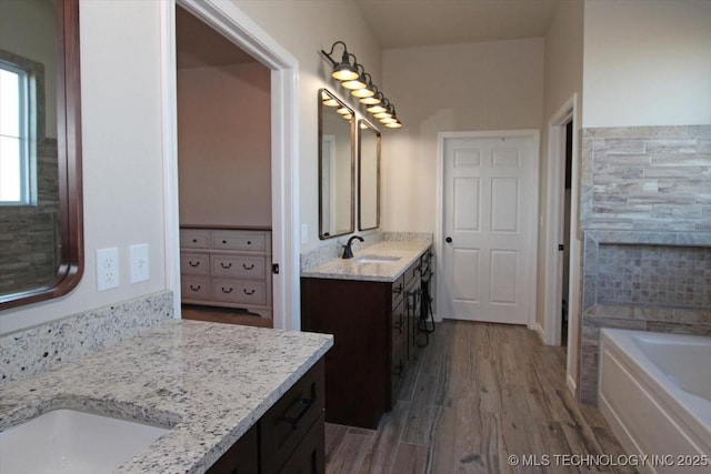 bathroom with a bath, vanity, and hardwood / wood-style flooring