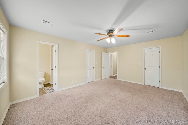 unfurnished bedroom featuring carpet flooring, ensuite bathroom, and ceiling fan