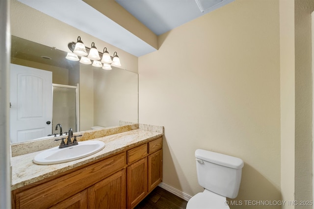 bathroom with vanity, toilet, and a shower with door