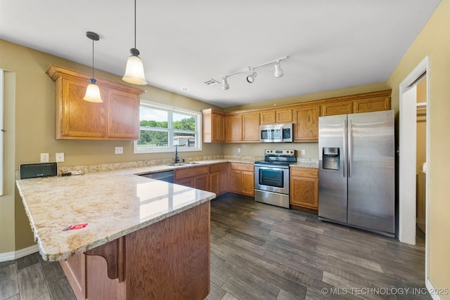 kitchen with sink, dark hardwood / wood-style floors, decorative light fixtures, kitchen peninsula, and stainless steel appliances