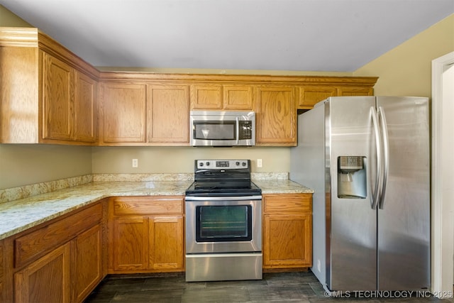 kitchen featuring light stone countertops, appliances with stainless steel finishes, and dark hardwood / wood-style flooring