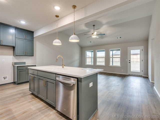 kitchen featuring sink, hanging light fixtures, a healthy amount of sunlight, and a center island with sink