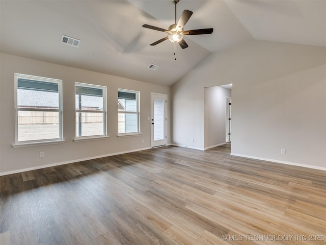 empty room featuring high vaulted ceiling, a healthy amount of sunlight, ceiling fan, and light hardwood / wood-style flooring