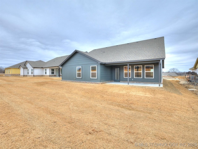 rear view of house featuring a yard and a patio area