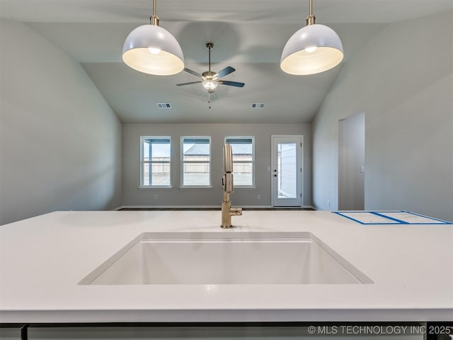 kitchen with lofted ceiling, sink, hanging light fixtures, and ceiling fan