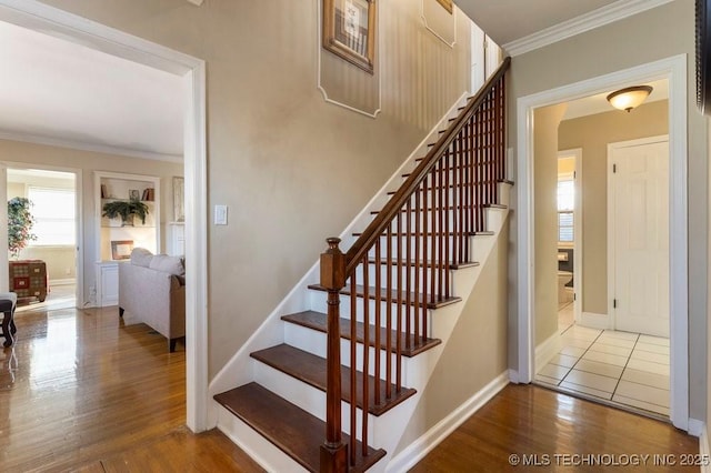 stairs featuring crown molding and wood-type flooring