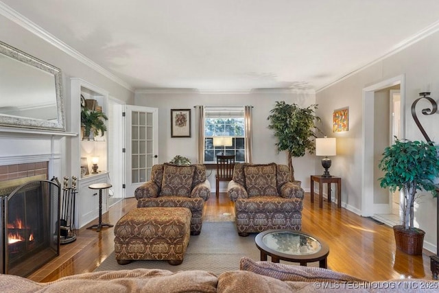 living room with crown molding, a fireplace, and hardwood / wood-style flooring