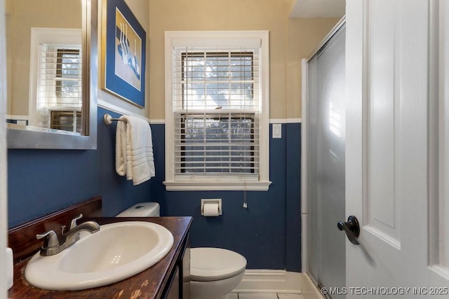 bathroom featuring vanity, toilet, and a shower with door