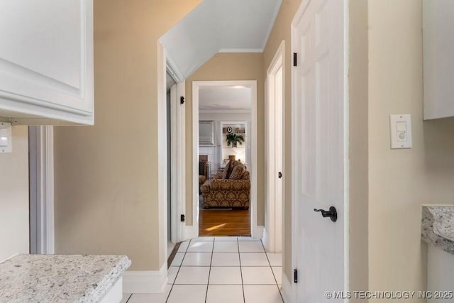 hallway with crown molding and light tile patterned flooring