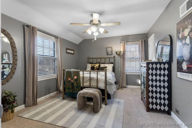 carpeted bedroom featuring ceiling fan, vaulted ceiling, and multiple windows