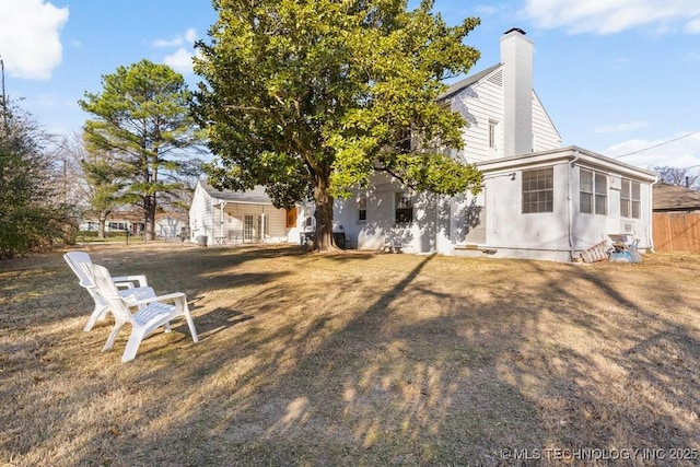 rear view of property featuring a lawn