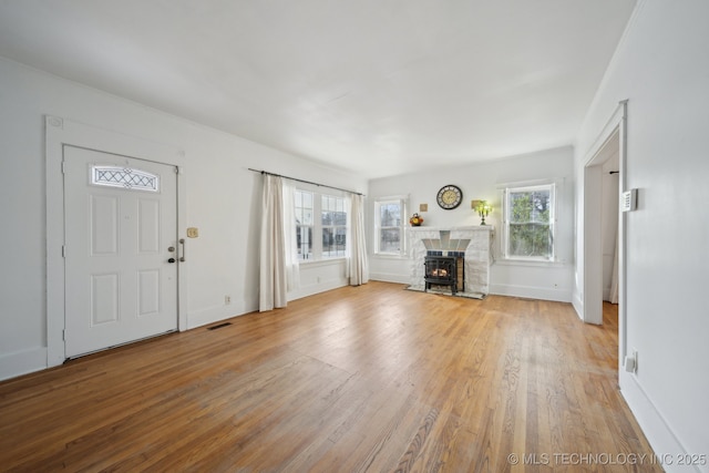 unfurnished living room with light hardwood / wood-style floors and a wealth of natural light