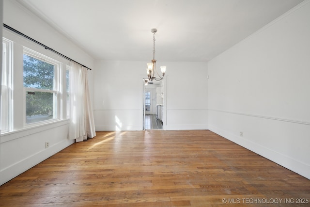 unfurnished dining area with hardwood / wood-style flooring and an inviting chandelier