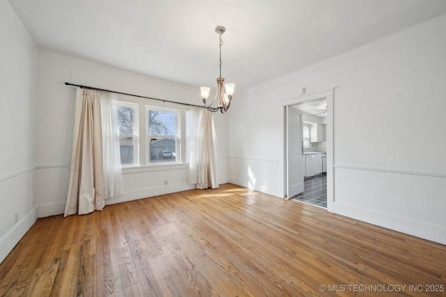 unfurnished dining area with hardwood / wood-style floors and ceiling fan with notable chandelier