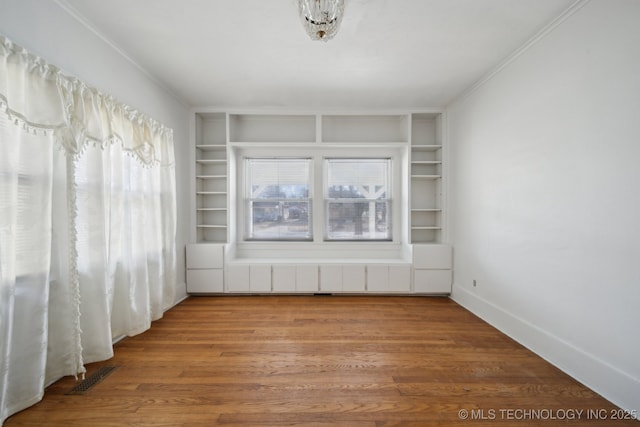 spare room featuring hardwood / wood-style flooring, ornamental molding, and radiator