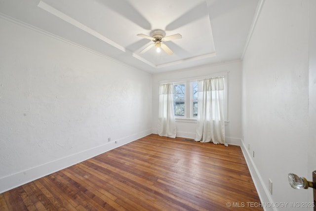 unfurnished room featuring hardwood / wood-style floors, a raised ceiling, and ceiling fan