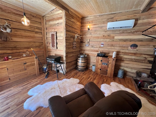 sitting room featuring a wall mounted AC, wooden walls, light hardwood / wood-style floors, and wood ceiling