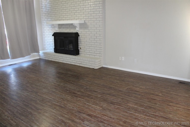 unfurnished living room with a fireplace and dark hardwood / wood-style flooring