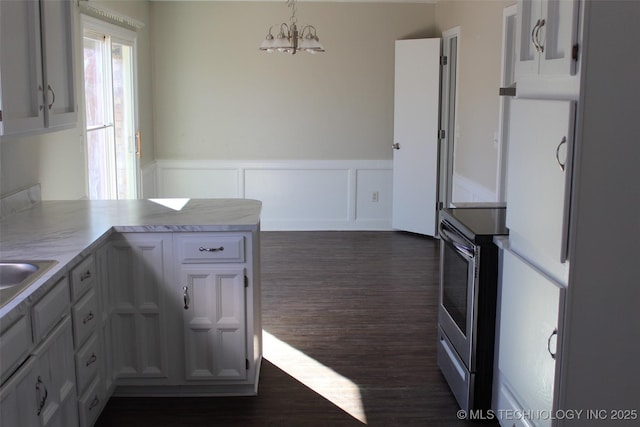 kitchen with hanging light fixtures, dark hardwood / wood-style floors, white cabinets, and kitchen peninsula