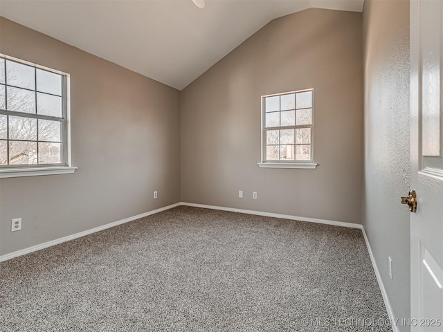 carpeted spare room with vaulted ceiling