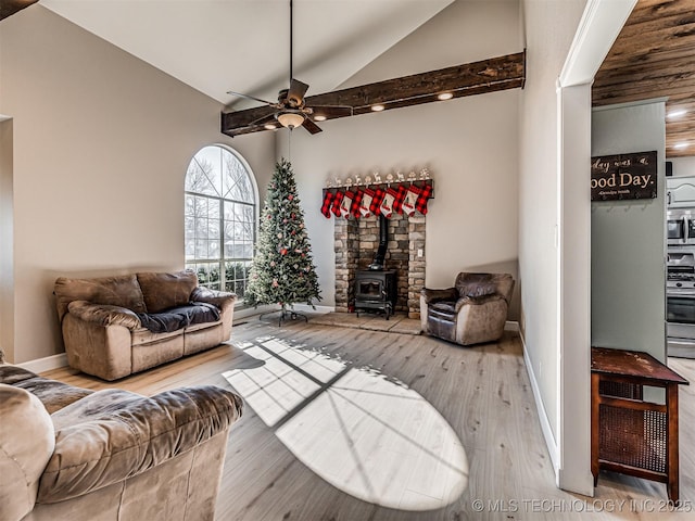 living room featuring ceiling fan, light hardwood / wood-style floors, a wood stove, and lofted ceiling