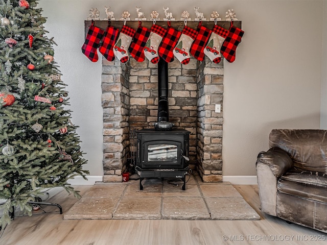 details featuring a wood stove and hardwood / wood-style flooring