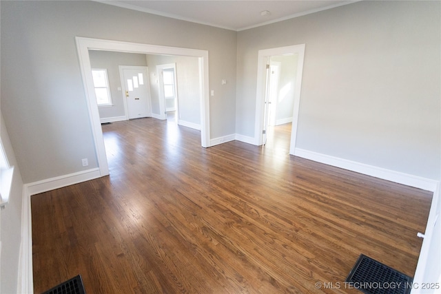 empty room with dark hardwood / wood-style flooring and ornamental molding