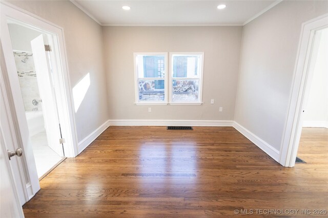 empty room with crown molding and dark wood-type flooring