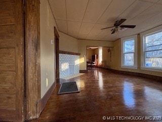 spare room featuring ceiling fan and dark parquet flooring