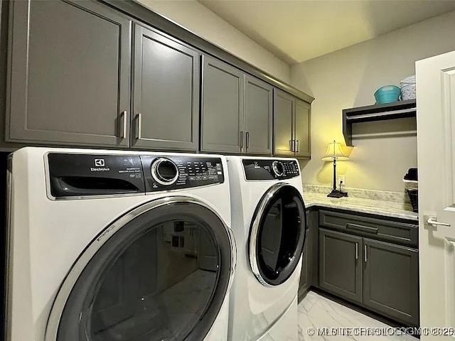 laundry area with washer and clothes dryer and cabinets