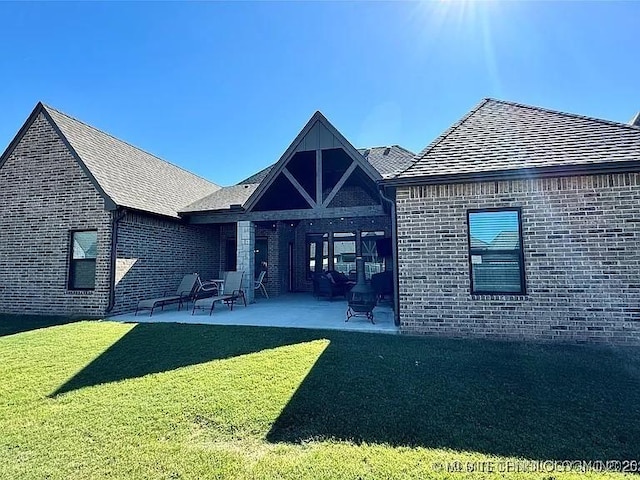 rear view of property with a patio and a lawn