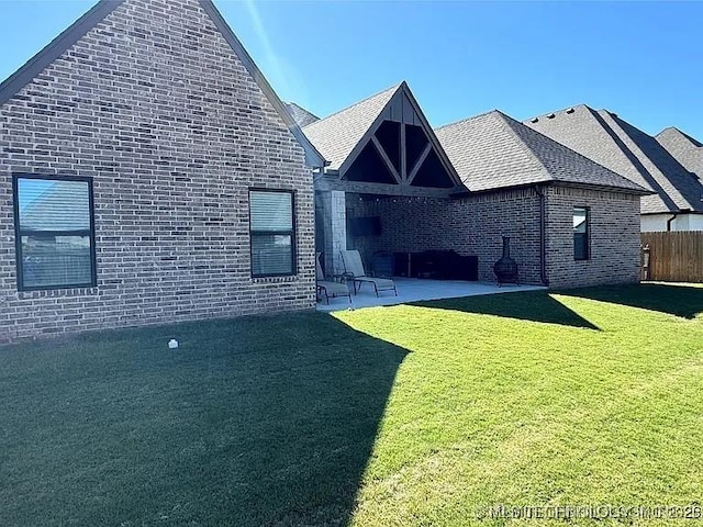 back of house featuring a lawn and a patio area