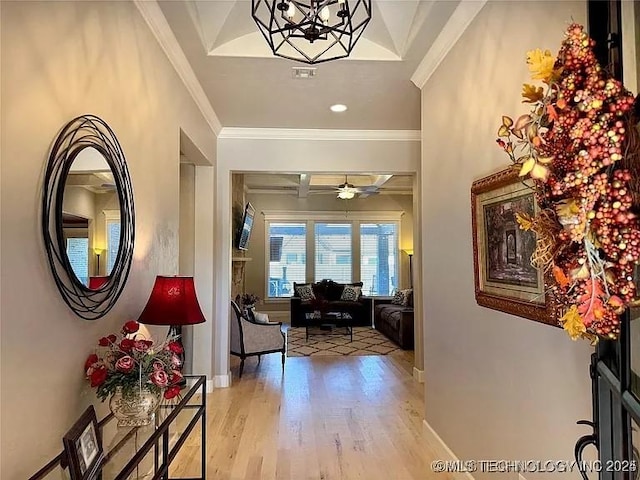 foyer entrance featuring light wood-type flooring, ceiling fan with notable chandelier, and ornamental molding