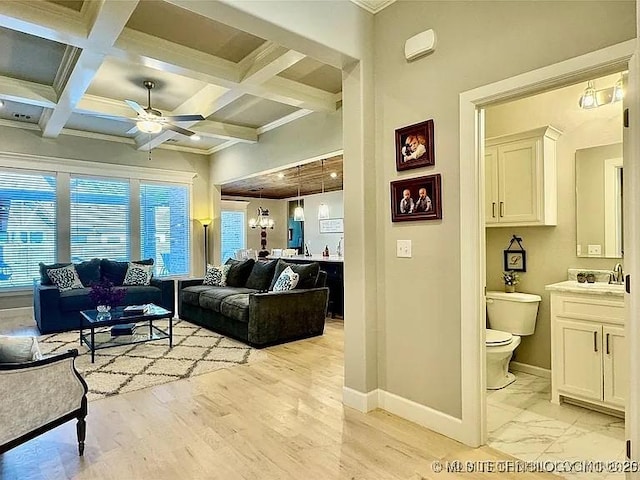 living room with beam ceiling, crown molding, ceiling fan with notable chandelier, and coffered ceiling