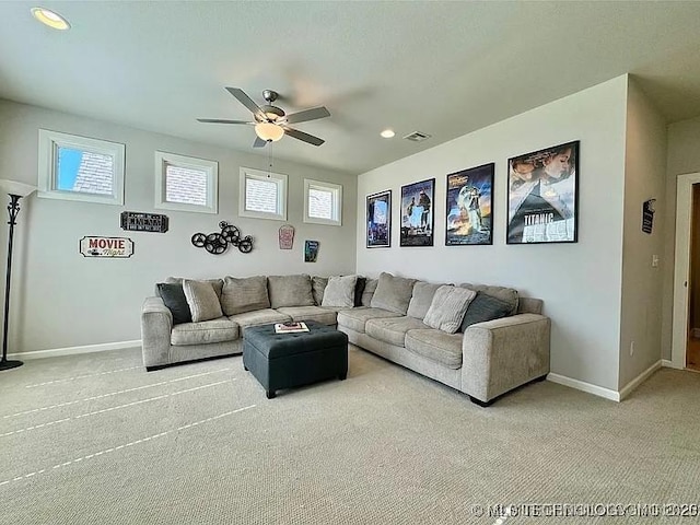 living room featuring carpet floors, ceiling fan, and a healthy amount of sunlight