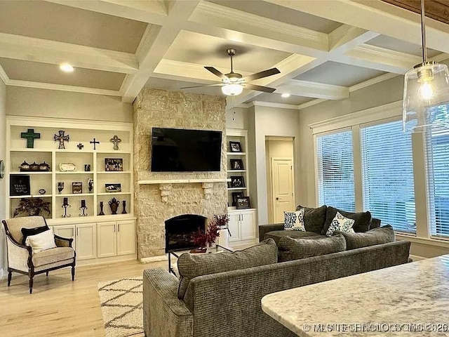 living room with beam ceiling, ceiling fan, light hardwood / wood-style flooring, a fireplace, and ornamental molding