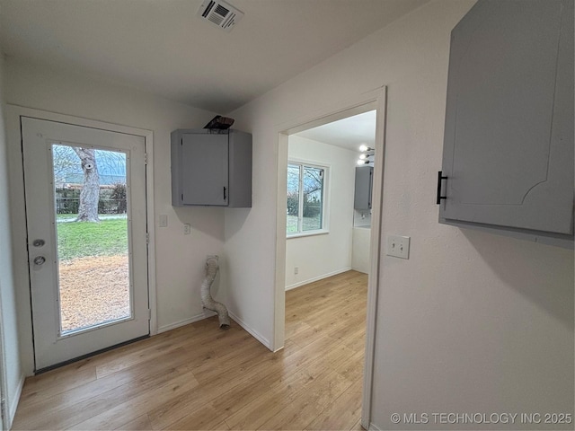 laundry room featuring light wood-type flooring and electric panel