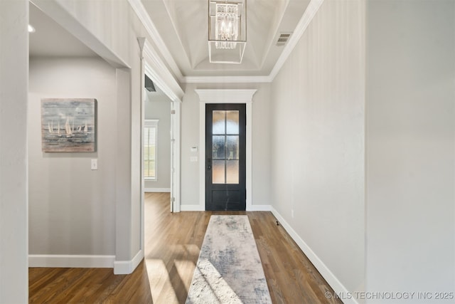 foyer entrance with a notable chandelier, crown molding, and hardwood / wood-style floors