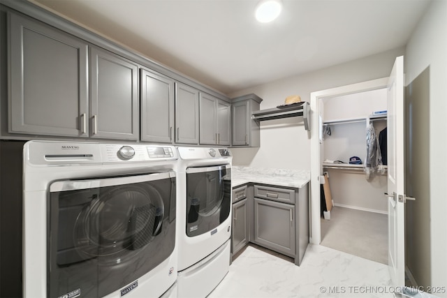 laundry area featuring separate washer and dryer and cabinets