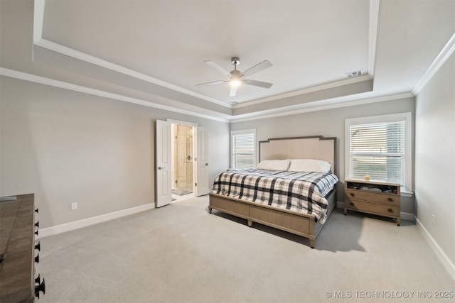 carpeted bedroom with ornamental molding, a raised ceiling, ceiling fan, and ensuite bathroom