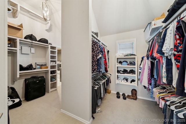 spacious closet featuring light carpet and a chandelier