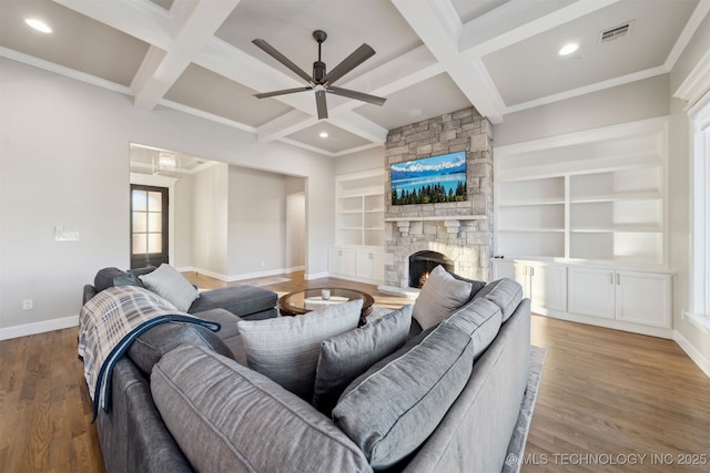 living room with a fireplace, hardwood / wood-style floors, coffered ceiling, built in shelves, and beam ceiling