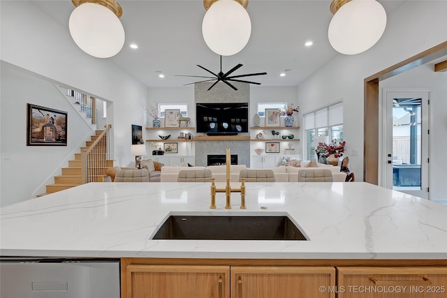 kitchen with light stone counters, hanging light fixtures, and a fireplace