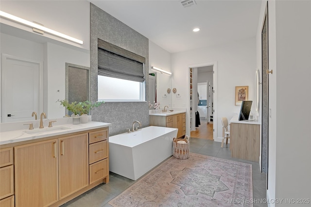 bathroom with vanity, a bath, and tile patterned flooring