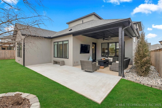 back of house with ceiling fan, a patio area, a yard, and an outdoor living space with a fire pit